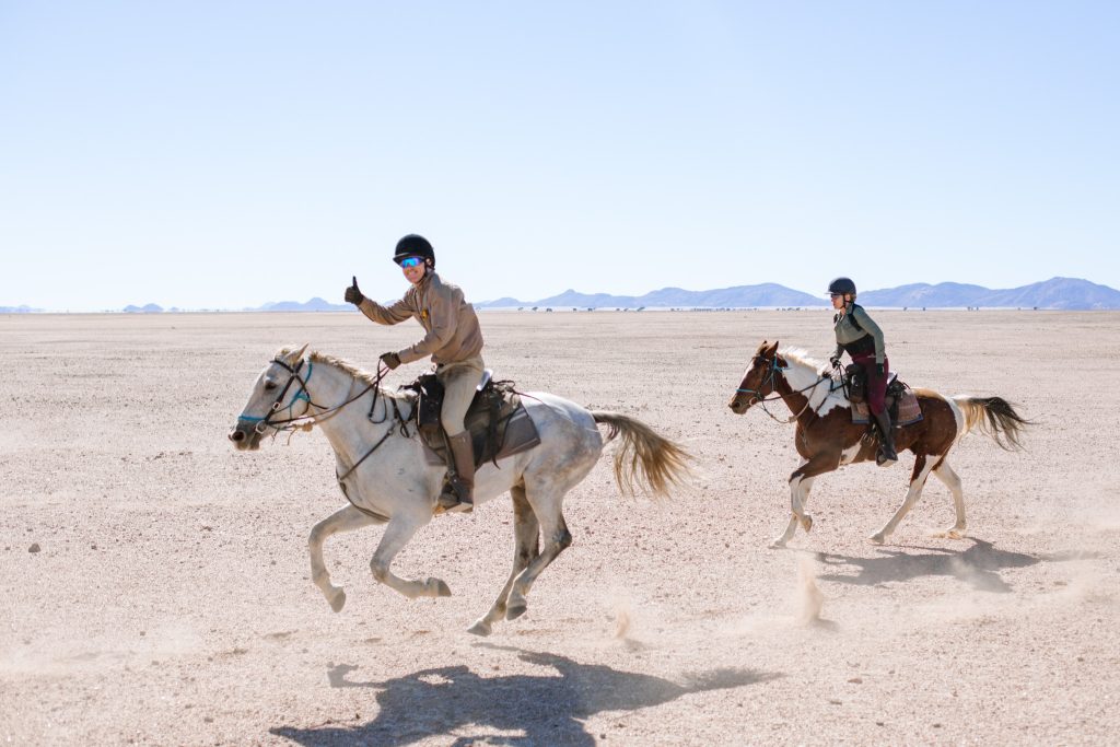 Horses running in the sand whilst on a African horseback safari 