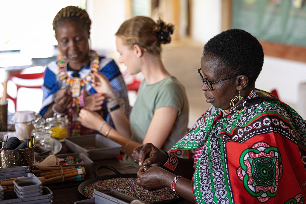 Women teach sustainable traveller how to make African beaded Jewellery 