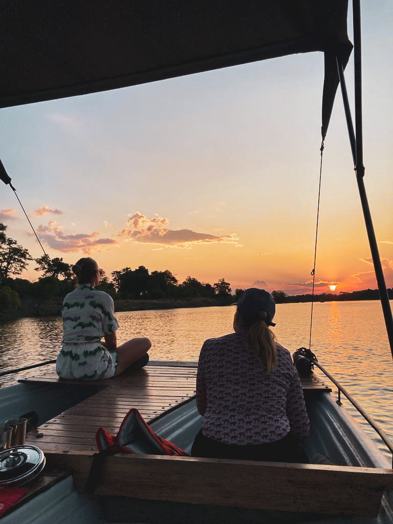 Travellers on a Chundukwa River Lodge activity watching the sunset over the water 