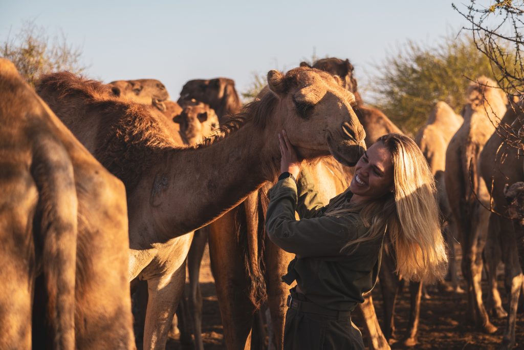 Sustainable traveller Emma Blunt gets up close to camel during an African safari 
