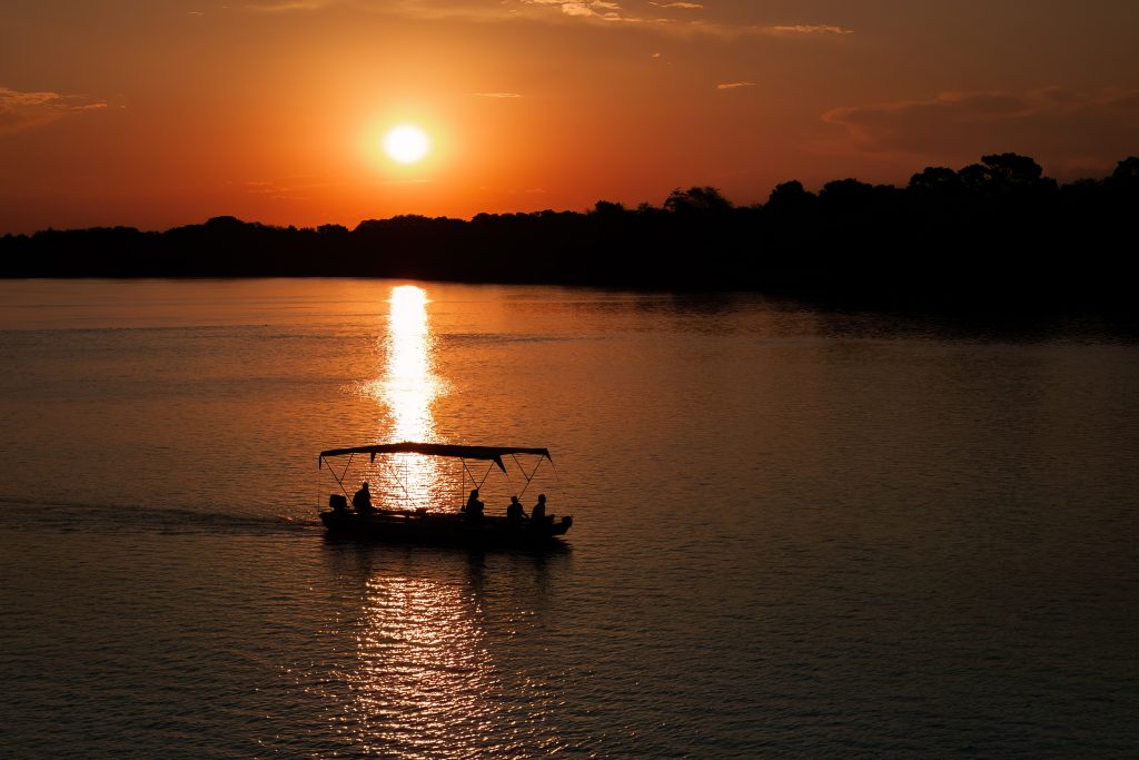 Sustainable travellers take boat ride at the sunset by the Chundukwa River Lodge, Zambia